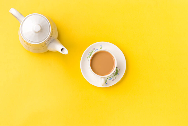 Milk tea on white cup with white kettle on yellow background stock image. - Photo, Image