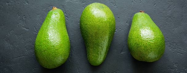 Raw fresh avocado on dark old concrete or stone background. Selective focus. Top view. - Foto, immagini
