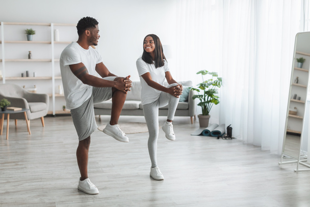 Νεαρό μαύρο ζευγάρι κάνει υψηλή άσκηση στο γόνατο - Φωτογραφία, εικόνα