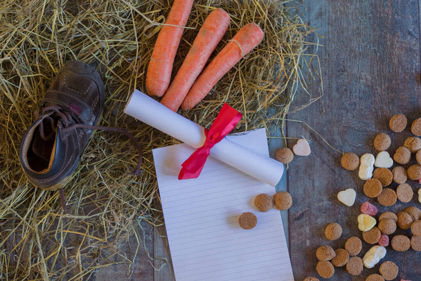 Schoen zetten ist eine holländische Tradition, bei der ein Kind einen Schuh mit Karotten für das Pferd des Sinterklaas und eine Zeichnung platziert, um am nächsten Tag Geschenke und Süßigkeiten zu erhalten.. - Foto, Bild