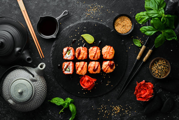 Rouleaux traditionnels appétissants de Sushi sur une plaque de pierre noire. Cuisine japonaise. Vue du dessus. - Photo, image
