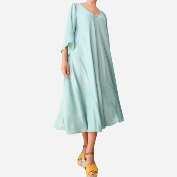 A female posing on a white background wearing a light blue midi dress with yellow and brown wedge sandals - Fotó, kép