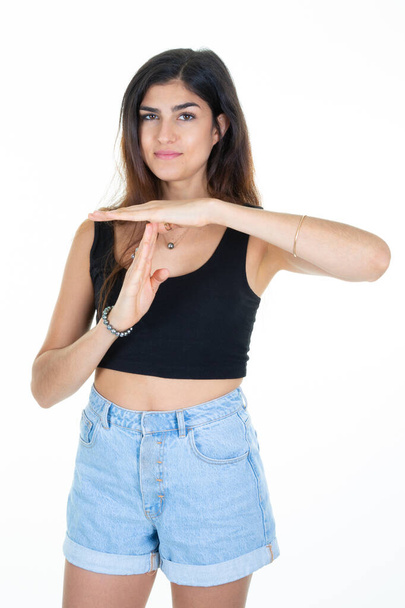 Νεαρή λεπτή γυναίκα ομορφιά κατά το λευκό φόντο δείχνει χέρι δάχτυλο χειρονομία timeout - Φωτογραφία, εικόνα