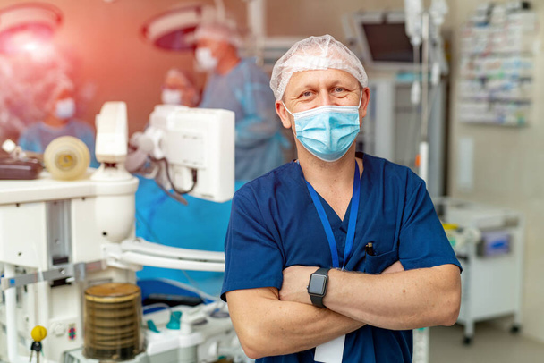 Male surgeon looking at camera at hospital. Professional surgery doctor in mask. - Фото, зображення