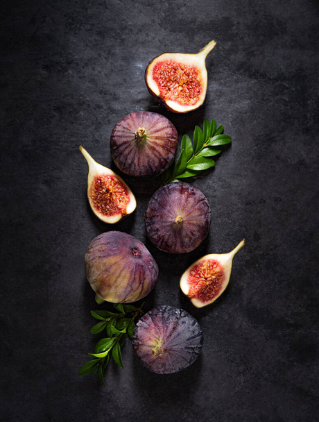 Flat lay with fresh ripe figs  on a dark gray background. Concept healthy food. Copy space and top view. - Photo, Image