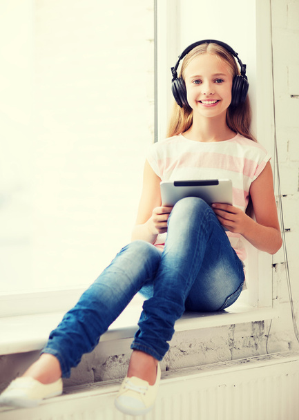 girl with tablet pc and headphones at home - Fotografie, Obrázek