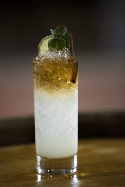 A vertical shot of an alcohol cocktail on a wooden barrel - Fotó, kép