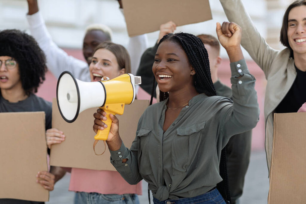 Emocionada mujer afroamericana con altavoz sobre multitud - Foto, Imagen