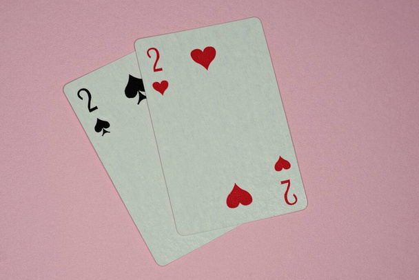 two game cards with deuces lie on a pink table - Photo, Image