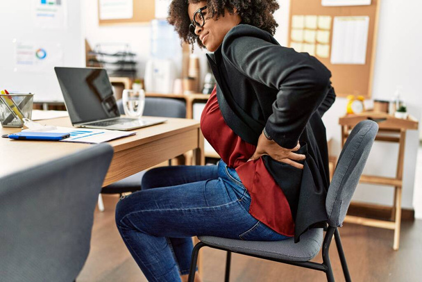 Giovane donna afroamericana che soffre di mal di schiena che lavora in ufficio - Foto, immagini