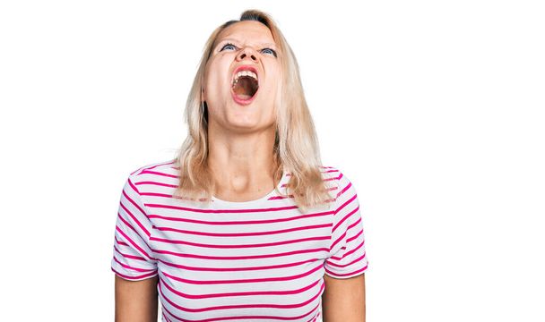 Young caucasian woman wearing casual clothes angry and mad screaming frustrated and furious, shouting with anger. rage and aggressive concept.  - Foto, Imagem