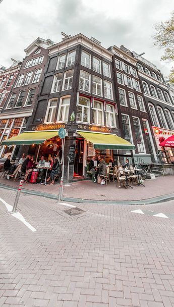 Amsterdam, the Netherlands - October 14, 2021: Street view and generic architecture in Amsterdam with typical Dutch style buildings. Amsterdam is one of Europe's most visited tourist destinations. - Foto, Imagen