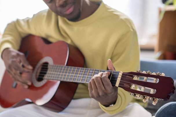 Χέρια του νεαρού Αφρικανού που παίζει κιθάρα μπροστά στην κάμερα - Φωτογραφία, εικόνα