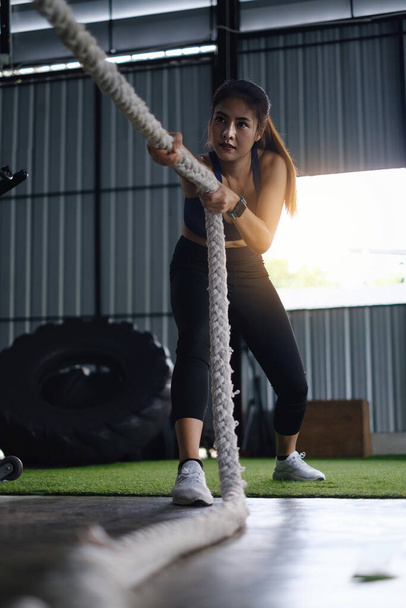 Femme travaillant avec la corde de combat à la salle de gym. Concept de personnes modernes en santé - Photo, image