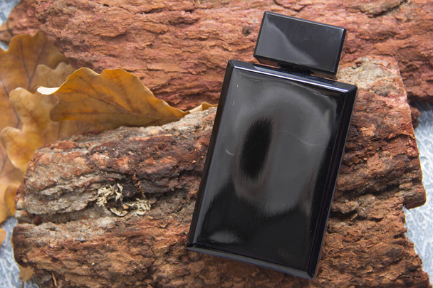 Mock up of a black bottle of men's perfume on a brick gray wall background. Place for text. - Foto, immagini