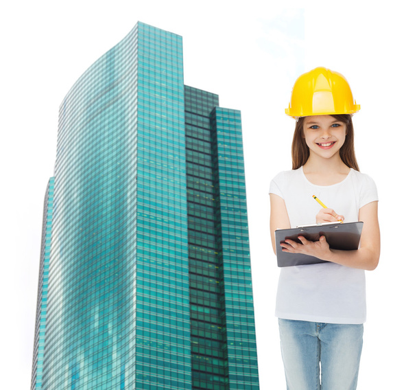 smiling little girl in hardhat with clipboard - Фото, изображение