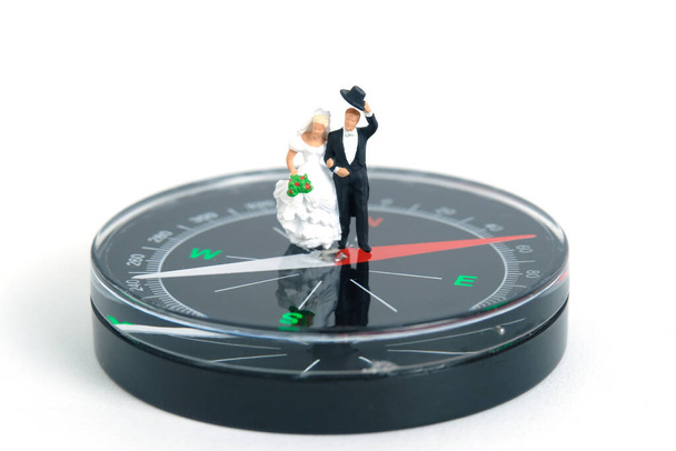 Wedding marriage newlywed direction concept miniature people, toys photography. Bride and groom standing above podium platform isolated on pink background. Image photo - Photo, Image