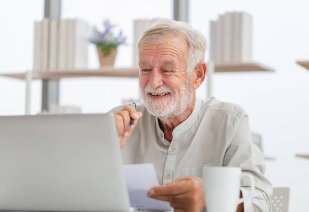 Портрет старшого чоловіка, який використовує ноутбук вдома, старший чоловік у вітальні з переглядом ноутбуків в Інтернеті на сучасному комп'ютерному гаджеті
 - Фото, зображення