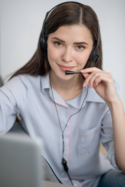 A pretty dark-haired operator of call canter working from home - Photo, Image
