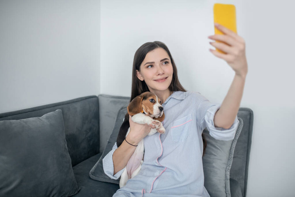 Una giovane donna carina che fa selfie con il suo cucciolo - Foto, immagini