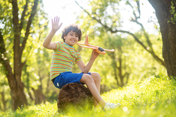 Smiling boy with toy airplane in park - Фото, зображення