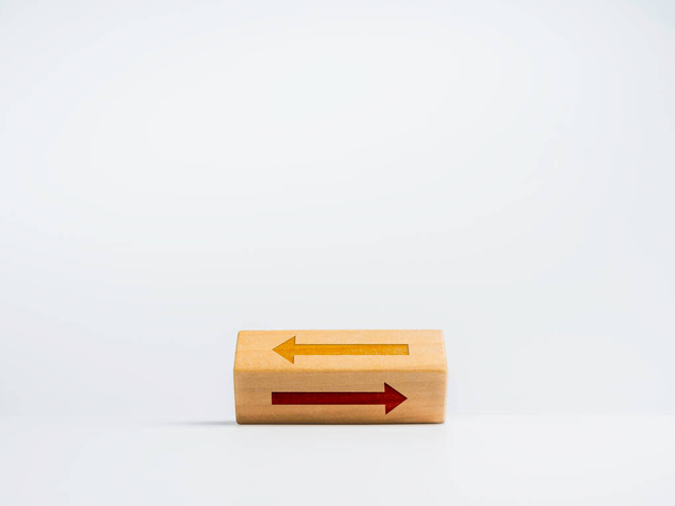 Flipping blocco di legno con due frecce diverse icona che si muove in senso opposto su sfondo bianco. Scegliere il percorso corretto tra sinistra e destra. Concetto decisionale. - Foto, immagini