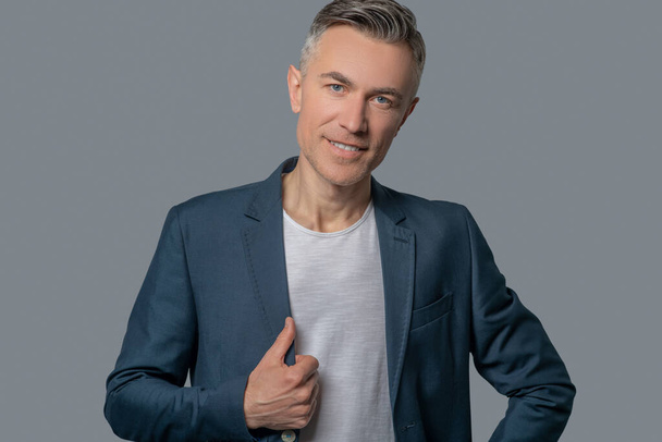 Attractive mature man in gray jacket - Foto, Imagen