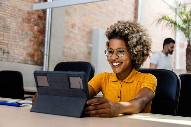 Usmívající se Afroameričanka pracující s digitálním tabletem v kanceláři. Kopírovat prostor. - Fotografie, Obrázek