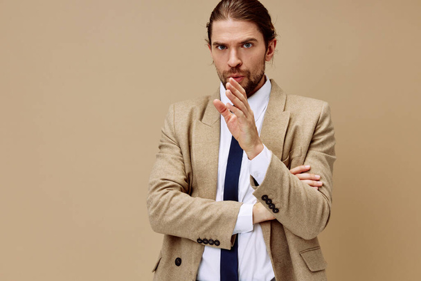 μοντέρνο άνθρωπος συναισθηματική άνθρωπος σε κοστούμι χειρονομία με τα χέρια μπεζ φόντο - Φωτογραφία, εικόνα