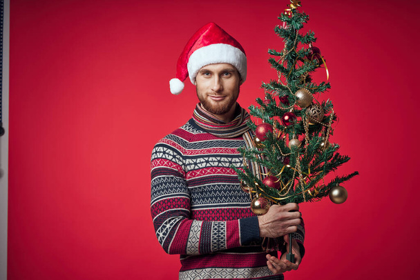 uomo in vestiti di anno nuovo Albero di Natale in mani giocattoli emozioni di vacanza - Foto, immagini