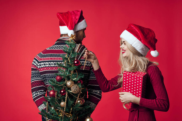 cheerful young couple in Santa hats Christmas tree toys decorations - Photo, Image