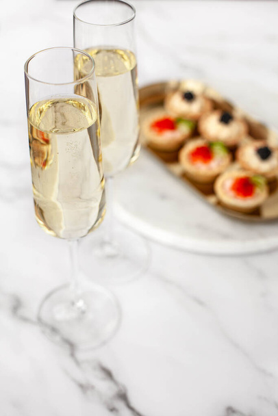 canape with black caviar and soured cream near glass with champagne - Foto, immagini