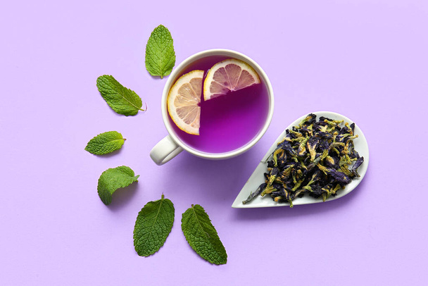 Renkli arkaplanda bir fincan organik kelebek çayı ve nane. - Fotoğraf, Görsel