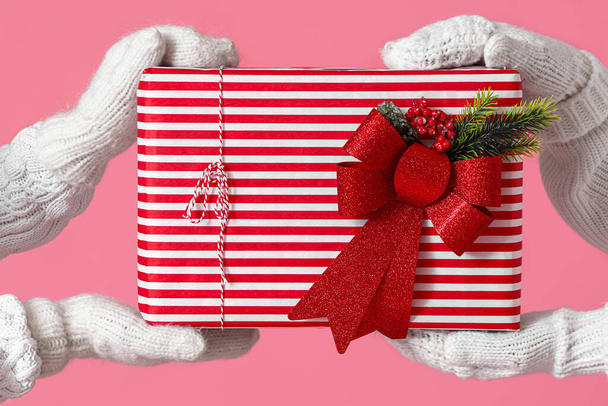 Women holding big Christmas gift box on pink background, closeup - Fotoğraf, Görsel