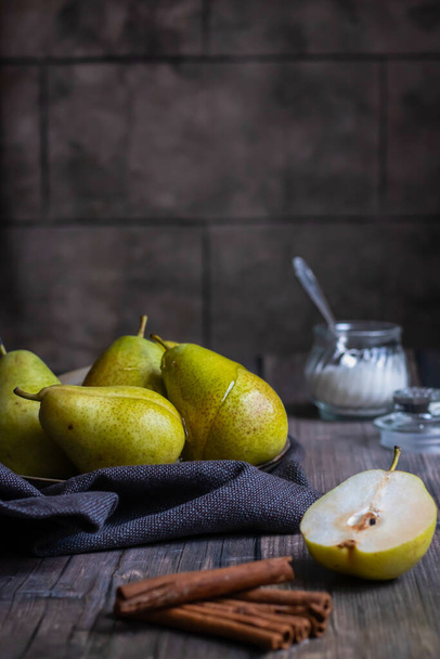 Green pears in honey with a sugar bowl and cinnamon sticks on a wooden table - Φωτογραφία, εικόνα