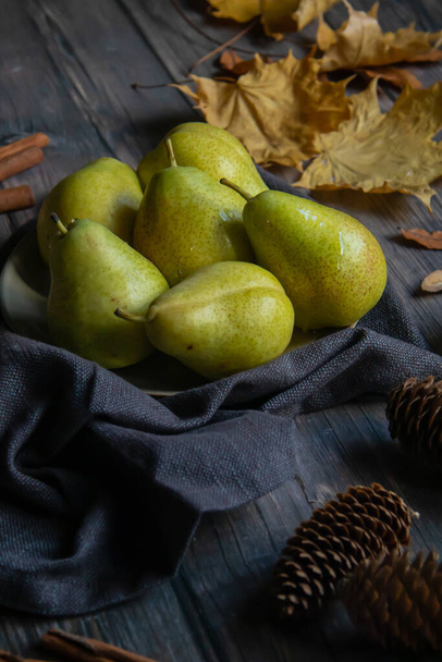 green pears in a plate on a wooden table - Fotoğraf, Görsel