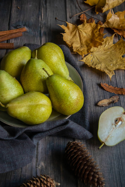 green pears in a plate on a wooden table - Photo, Image