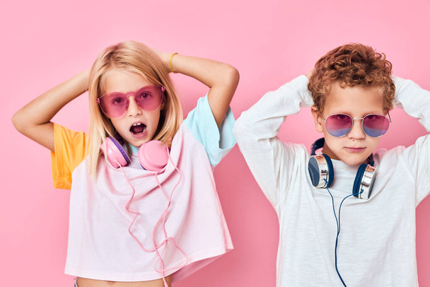 Portrait d'une fille et un garçon écouteurs de divertissement jouant casual enfants mode - Photo, image