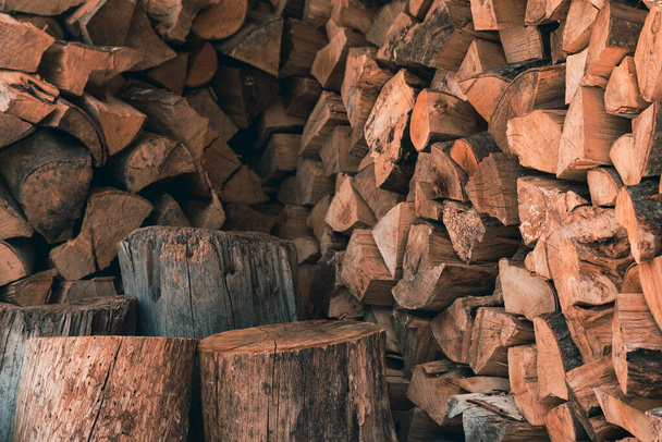 The chopped woodpile in the shed stacked for the heating season in winter - Foto, afbeelding