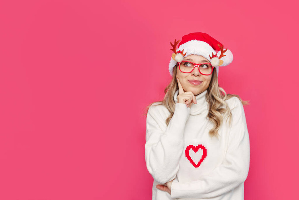 young beautiful woman wearing santa claus hat and glasses over pink background. - Fotoğraf, Görsel