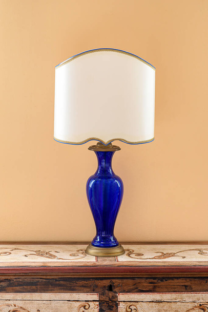 50 'li yılların lambası mavi cam askılı ve beyaz tonlu ahşap klozete yerleştirilmiş sarı duvarlı odada. - Fotoğraf, Görsel