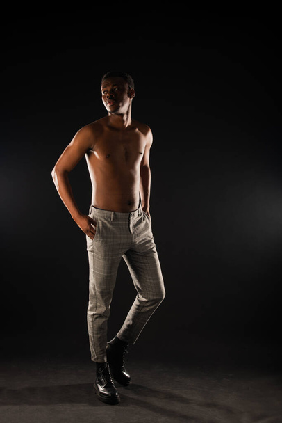 africano nero maschio è avendo un grande posa su nero sfondo in studio - Foto, immagini