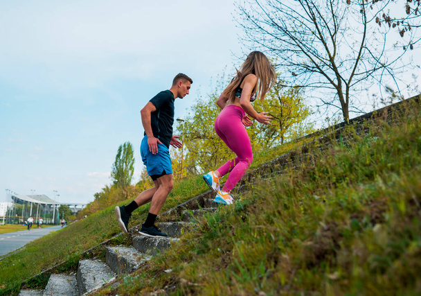 Jeune couple heureux jouissant d'un mode de vie sain tout en faisant du jogging à l'étage à travers la belle forêt ensoleillée, l'exercice et le concept de fitness - Photo, image