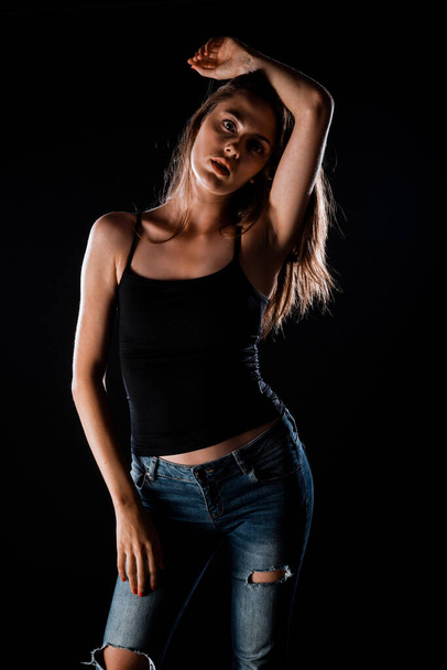 Portrait of a beautiful stylish woman posing against black background - Фото, изображение
