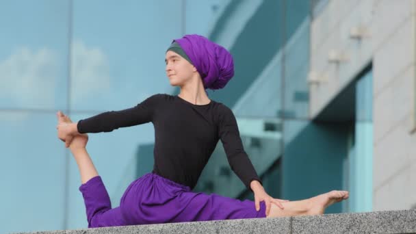 Μουσουλμανική ισλαμική αραβική ινδή γυναίκα σε hijab κάνει προπόνηση γιόγκα δύναμη προπόνηση εξάσκηση γυμναστήριο γυναικείο αθλητισμό σε εξωτερικούς χώρους κορίτσι διαλογισμό που εκτείνεται στην πόλη κάθεται asana έννοια ευελιξίας - Πλάνα, βίντεο