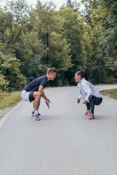 Мужчины и женщины-спортсмены готовятся к марафону, бегу, тренировкам. Понятие здорового образа жизни. - Фото, изображение