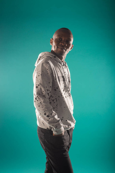 Casual dressed black male is posing in studio on blue background - Foto, immagini