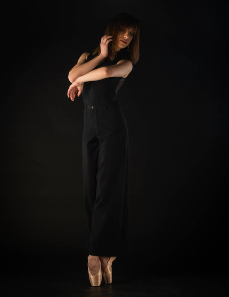 Krásná baletka drží perfektní baletní postoj na černém pozadí - Fotografie, Obrázek