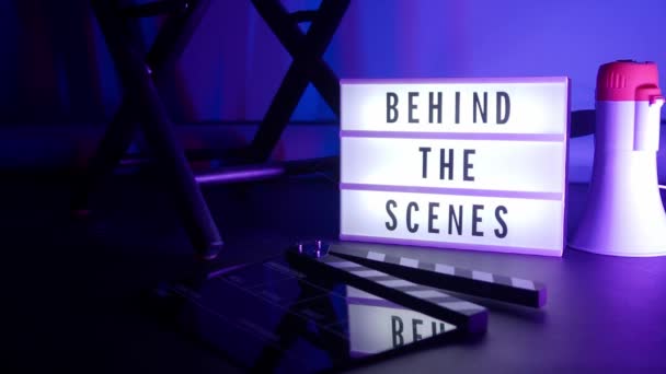 Sinema ışığı kutusundaki sahne arkası mektupları. Sahne arkasındaki beyaz LED ışık kutusu üzerindeki siyah metin. Dekorlar arasında megafon film alkışları ve stüdyoda yönetmen koltuğu var. video yapımı için - Video, Çekim
