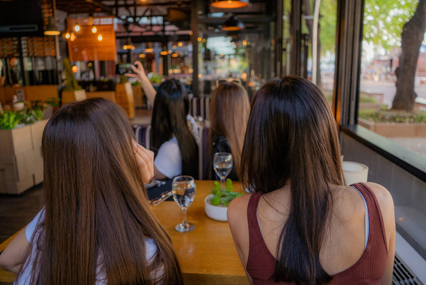 Четыре красивые и удивительные девушки делают селфи в кафе, позируя - Фото, изображение